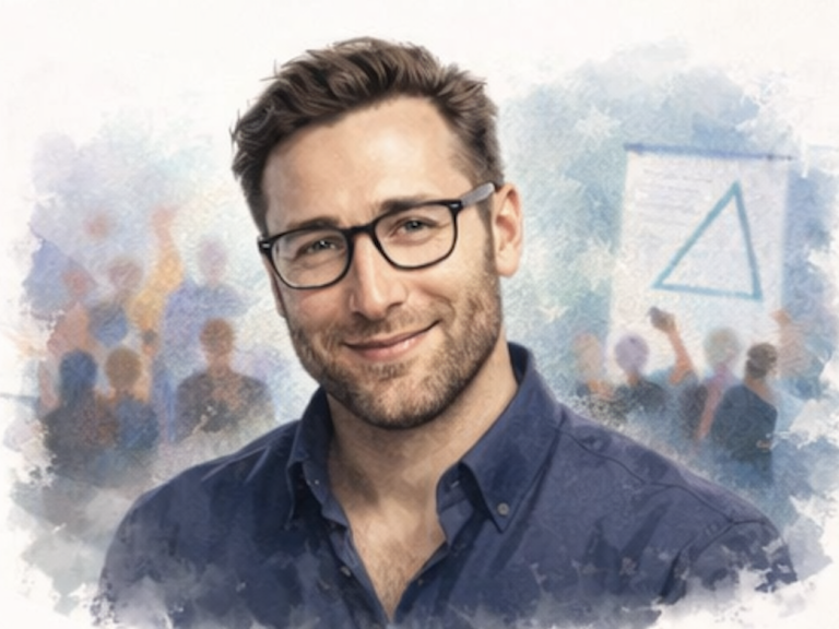 Smiling man with glasses in front of a blurred audience and a presentation board.